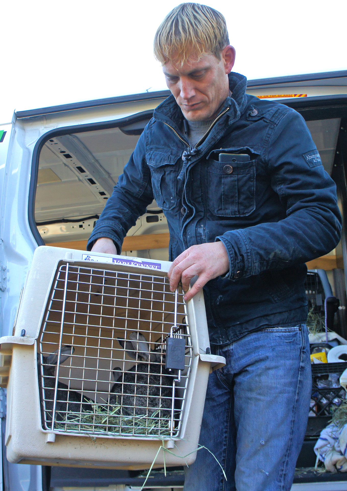 Ken holding a carrier containing two rabbits